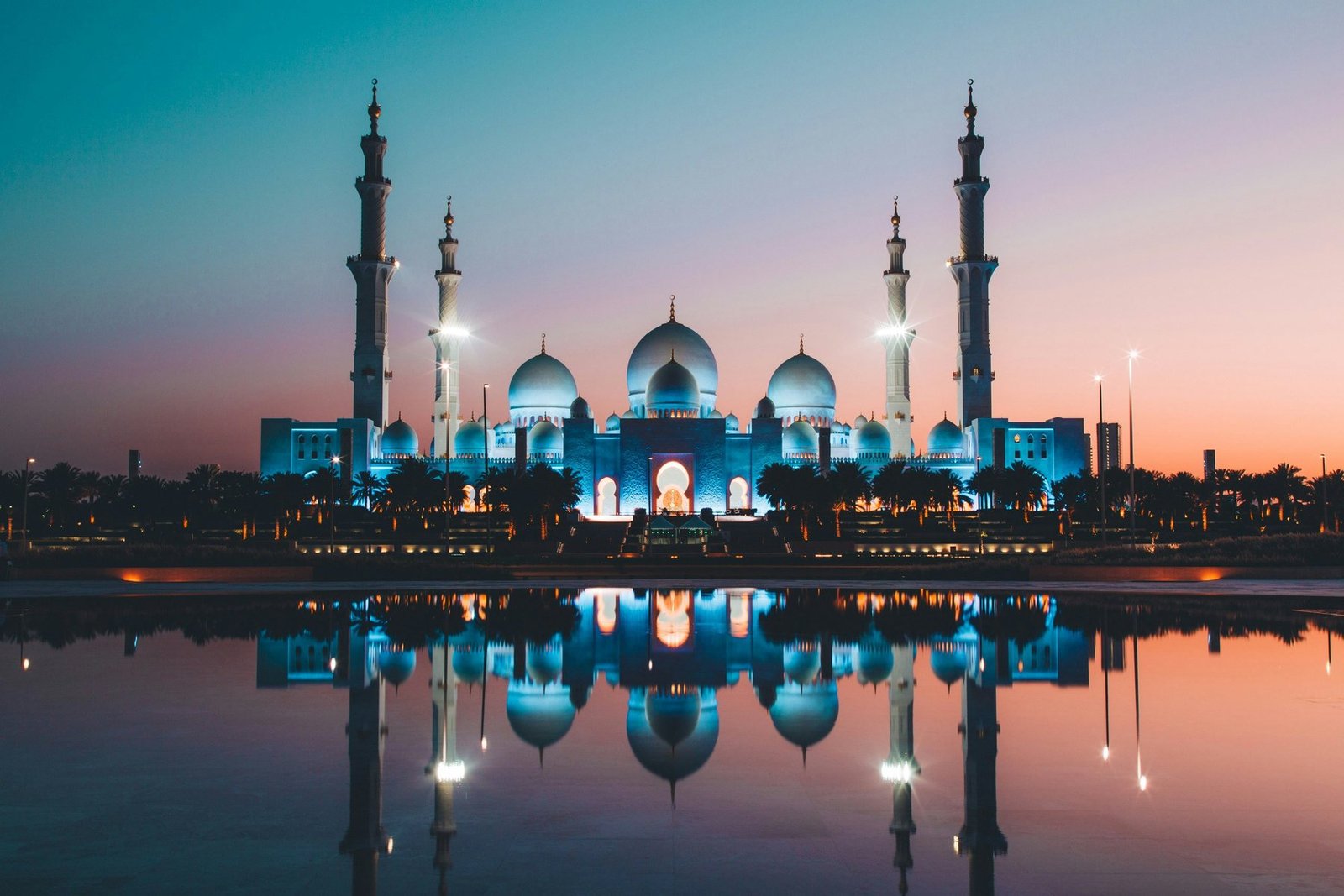 Sheikh Zayed Grand Mosque reflected in water at sunset